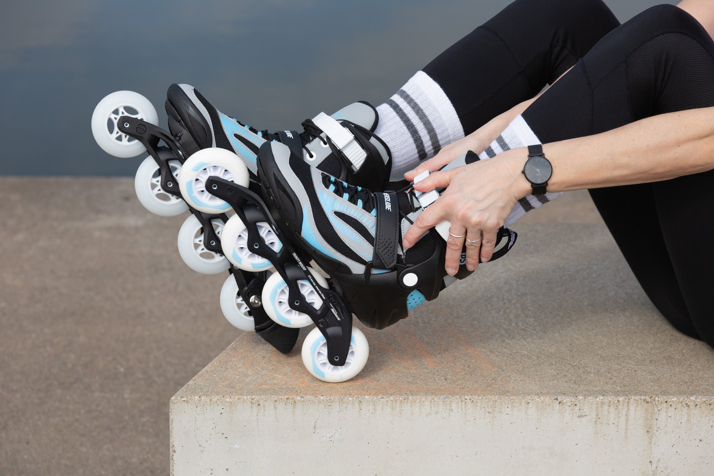 Close up of a female inlineskater lacing in to her Powerslide Phuzion skates while sitting.